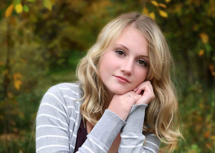 29-senior_girl_blonde_curls_pretty_model_fence_green_grey_clothes.jpg