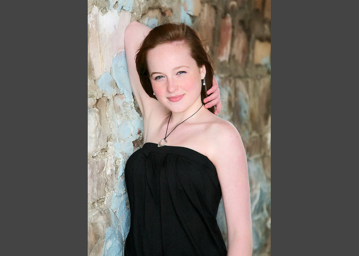 high_school_senior_girl_black_shirt_leaning_wall.jpg